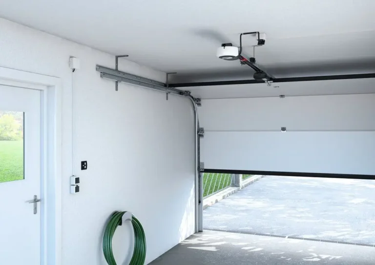 Close-up of a garage door mechanism showing the metal tracks and springs. The door has white panels, and a red tag is attached to the track. The image is time-stamped in the bottom right corner at 8:29 PM. and this image belongs to article 'How to Make Perpendicular Garage Door Horizontal Tracks'
